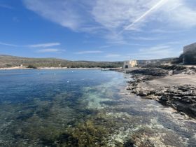 A picturesque view of a serene coastline with clear waters and rocky shores, perfect for exploring hidden beaches and enjoying nature's beauty.