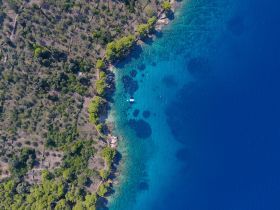 A stunning aerial view of a secluded coastline with crystal-clear waters, perfect for exploring hidden beaches and enjoying nature's beauty.