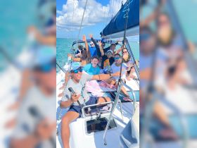 A lively group enjoys a fun day sailing, celebrating with drinks and laughter aboard a boat — perfect for unforgettable moments on the water.