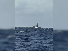 An unclear image of a submerged vessel in open water, possibly a submarine, with no identifiable features or people present.