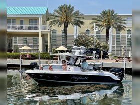 A lively group waves from their boat at the dock, enjoying a sunny day on the water — perfect for fun outings and celebrations.