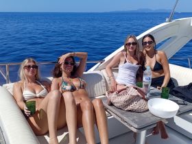 A group of friends relaxes on a yacht, enjoying the sun and sea, perfect for a fun day out on the water.