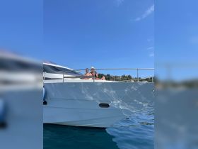A couple enjoys a sunny day on the deck of a yacht, perfect for summer relaxation and scenic views on the water.