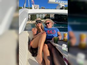 A couple enjoys a sunny day on a boat, relaxing with drinks and smiles, perfect for romantic getaways or celebrations on the water.