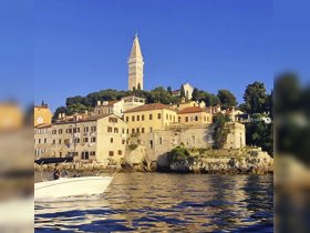 A scenic view of a boat cruising past picturesque coastal buildings, showcasing the charm of the harbor and the stunning architecture of the town.