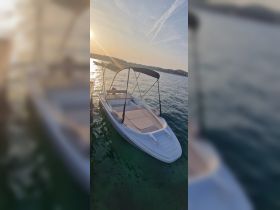 A sleek speedboat docked in tranquil waters at sunset, showcasing its spacious seating and stylish design — perfect for leisurely outings on the water.