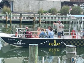 A lively group enjoys a charter boat experience, showcasing the fun of boat tours and taxi services in a scenic marina setting.