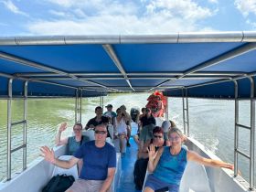 A cheerful group waves from inside a boat, enjoying their adventure on the water — perfect for group outings and memorable experiences.