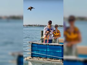 A joyful family enjoys a day on the water, with children safely in life jackets, capturing the essence of fun and safety during their boating adventure.