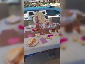 A beautifully arranged table on a boat featuring decorative elements, snacks, and drinks, perfect for a festive celebration or gathering on the water.