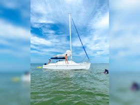 A fun day on the water with friends aboard a catamaran, featuring swimming and sunbathing in a beautiful setting.