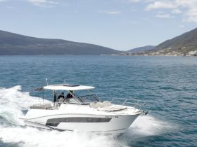 A sleek speedboat glides through the sparkling waters, showcasing an exhilarating day on the water with guests enjoying the ride.