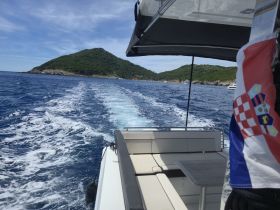 A scenic view from a boat cruising through clear waters, showcasing a lush island in the background — perfect for exploring the beautiful coastline.