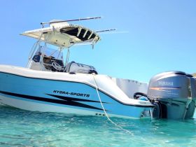 A sleek Hydra-Sports boat captured in clear turquoise waters, showcasing its stylish design and powerful Yamaha engine — perfect for a day of adventure on the water.
