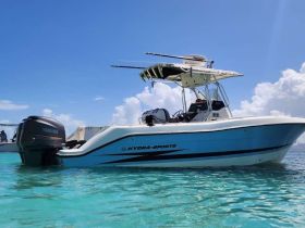 A sleek Hydra-Sports boat glides through crystal-clear waters, showcasing its stylish design and powerful Yamaha engine — perfect for a day of adventure on the water.