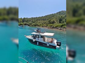 A lively scene featuring a group enjoying their time on a boat in crystal-clear waters, surrounded by lush greenery — perfect for summer adventures and coastal exploration.