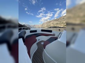 A cozy seating area inside a boat, featuring plush cushions and a stylish design, perfect for relaxing while enjoying scenic views.