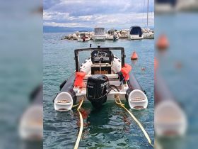 A sleek view of a motorboat equipped with a Suzuki engine, anchored in clear waters near a dock, showcasing its design and functionality.