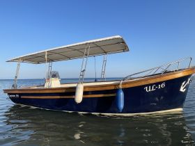 A beautiful view of the 'Captain Ali' boat, showcasing its sleek design and structure against a clear blue sky, perfect for a day on the water.