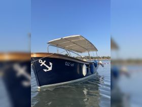 A beautiful view of a classic boat with an anchor design, docked and ready for a day on the water. Perfect for leisurely outings or private charters.