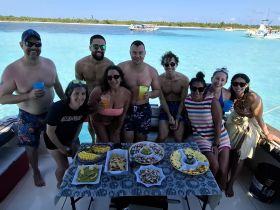 A lively group enjoys a fun day on the water with cocktails and delicious food, perfect for celebrations and memorable outings.