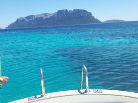 A stunning view of turquoise waters with an island backdrop, showcasing a perfect day on the boat.
