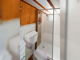 A well-designed boat bathroom featuring a shower and toilet, showcasing the comfort and amenities available on board.
