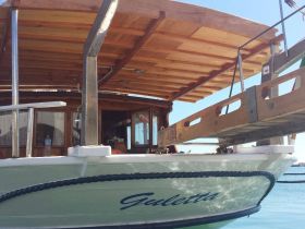 A close-up view of the 'Guletta' boat showcasing its wooden structure and hull, perfect for leisurely cruises or charters.