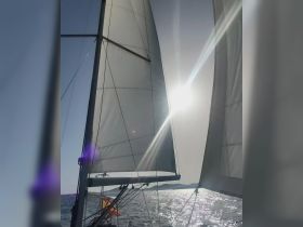 A stunning view of the sails of a sailboat catching the sunlight, showcasing the beauty of sailing on open waters.