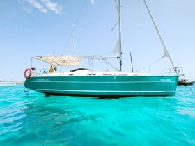 A stunning side view of a Cyclades 39.3 yacht gliding through crystal-clear turquoise waters, perfect for sailing enthusiasts and charter adventures.