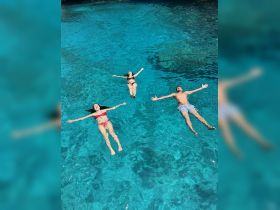 A group of friends enjoys a refreshing swim in crystal-clear waters, perfect for a fun day out on the boat.