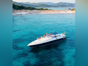 A lively group enjoys a day on a sleek boat in crystal-clear turquoise waters, with a picturesque beach in the background — perfect for summer adventures and beach outings.