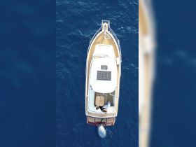 Aerial view of a couple enjoying time on a boat in deep blue waters, perfect for romantic getaways or scenic adventures.