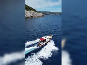 A scenic view of a boat cruising through deep blue waters, showcasing the thrill of on-water adventures amidst stunning coastal landscapes.