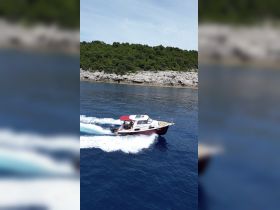 A motorboat speeds through crystal-clear waters, showcasing a beautiful coastal backdrop — perfect for exploring scenic destinations.