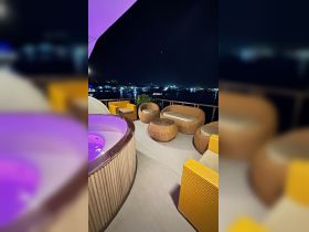 A cozy lounge area on a boat featuring stylish seating and a hot tub, perfect for relaxing under the stars while enjoying the waterfront view.