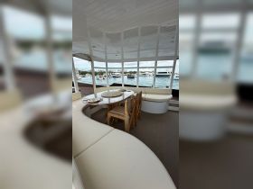 Interior view of a spacious dining area on a boat, featuring comfortable seating and a beautifully set table, perfect for enjoying meals while cruising.