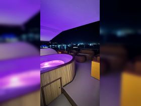 A luxurious jacuzzi illuminated in purple light on a boat deck at night, perfect for relaxation and evening gatherings under the stars.