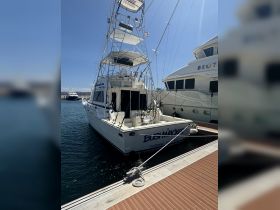 A striking view of the 'Bush Macker' yacht docked at the marina, showcasing its impressive structure and design against a clear blue sky.
