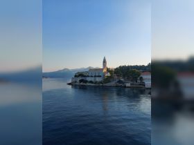 A picturesque view of a serene coastline with a charming church on the island, perfect for capturing the beauty of coastal destinations.