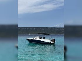 A sleek speedboat anchored in crystal-clear waters, showcasing the perfect setting for a day of relaxation and adventure on the sea.