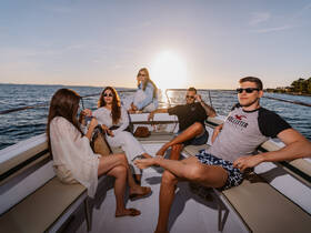 A group of friends enjoys a beautiful sunset on a boat, capturing the essence of summer fun and camaraderie on the water.