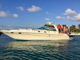 A lively group enjoys a day on the water, celebrating aboard a sleek boat, perfect for summer parties and fun outings.
