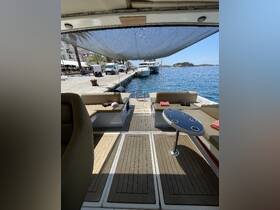 Interior view of a spacious boat cabin featuring comfortable seating and a stylish table, perfect for relaxing while enjoying the waterfront scenery.