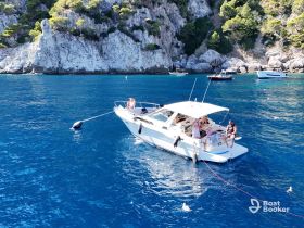 A lively group enjoys a day on the water aboard a boat, surrounded by stunning coastal scenery — perfect for summer adventures and relaxation.
