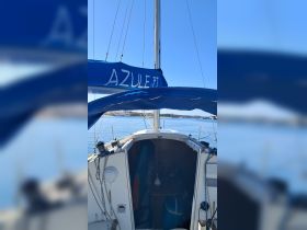 An interior view of a sailboat's helm and cabin area, showcasing the cozy space perfect for navigation and relaxation on the water.