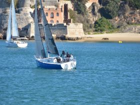 A picturesque scene of two sailboats navigating through calm waters, with a stunning coastal backdrop, perfect for sailing enthusiasts and scenic boat tours.