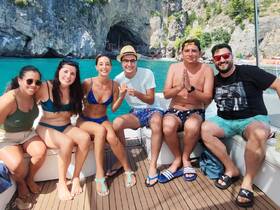 A lively group of friends enjoys a sunny day on a boat, capturing the joy of summer adventures on the water.