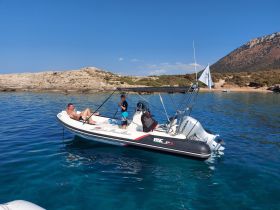 A family enjoys a relaxing day on a boat in clear waters, perfect for swimming and outdoor adventures.