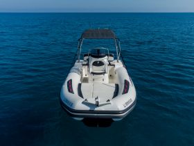 A sleek speedboat captured from the front, gliding through clear blue waters — perfect for thrilling adventures on the open sea.